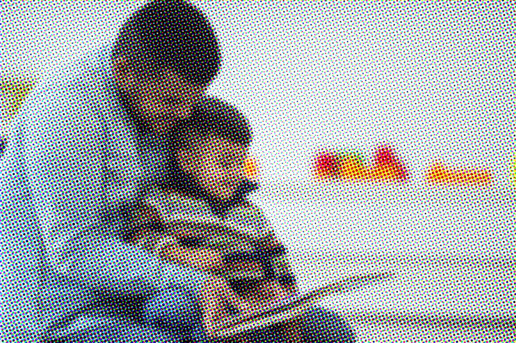 A father and son are reading a book together in their home.